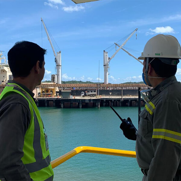 Funcionários da CS Infra trabalhando com paisagem ao fundo