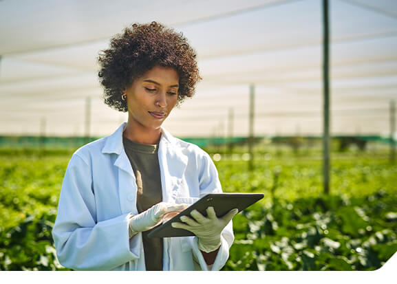 Cientista em campo com tablet analisando informações